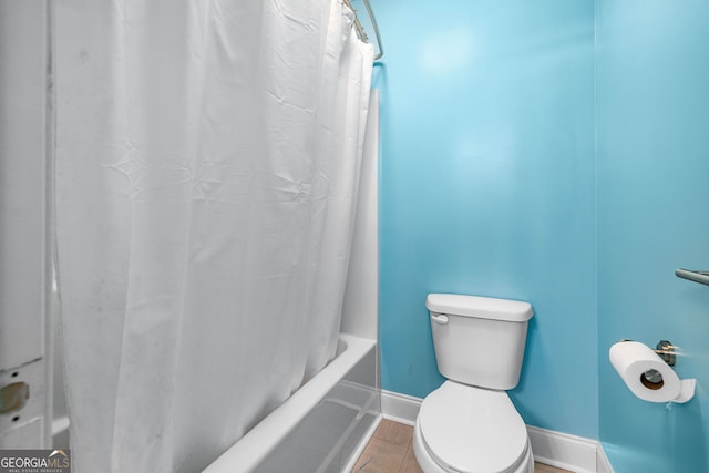 full bathroom featuring baseboards, toilet, and shower / bath combo with shower curtain