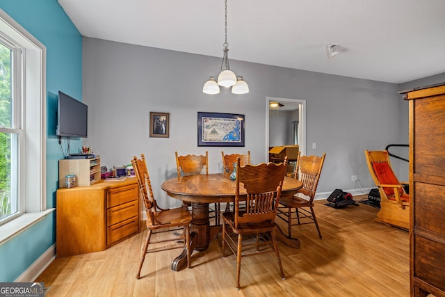 dining space with light wood-type flooring, healthy amount of natural light, and baseboards