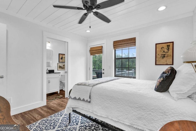 bedroom featuring dark wood finished floors, access to outside, recessed lighting, ensuite bathroom, and baseboards
