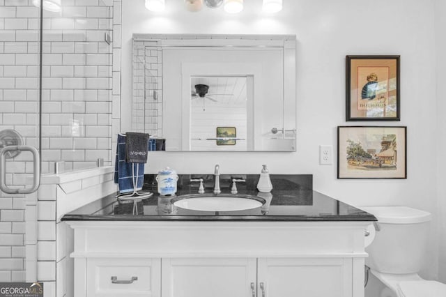 bathroom featuring vanity, toilet, and a tile shower