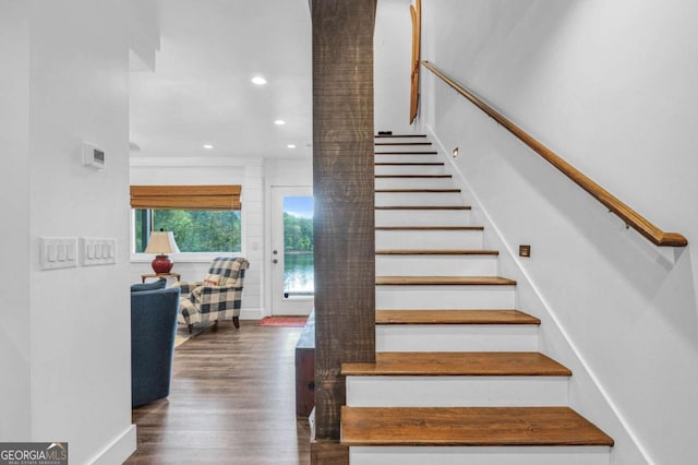 stairs featuring wood finished floors and recessed lighting