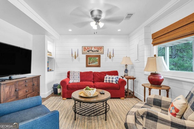 living area featuring a ceiling fan, wood finished floors, and baseboards
