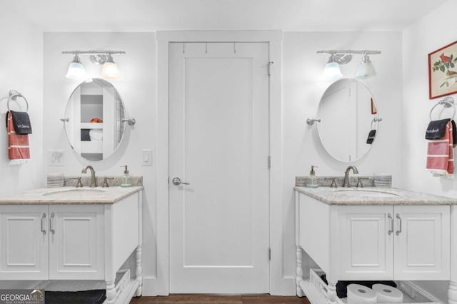 full bath with two vanities and wood finished floors
