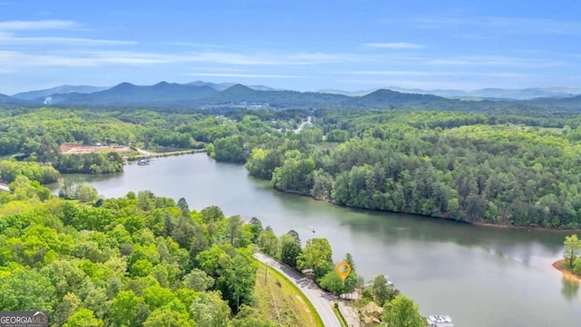 bird's eye view of a heavily wooded area and a water and mountain view
