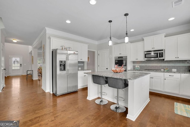 4050 Pleasant Woods Dr, Cumming, GA 30028 - kitchen featuring stainless steel appliances, white cabinets, a kitchen island, backsplash, and ornamental molding