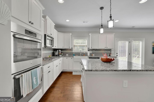 4050 Pleasant Woods Dr, Cumming, GA 30028 - kitchen with a sink, appliances with stainless steel finishes, a center island, backsplash, and ornamental molding