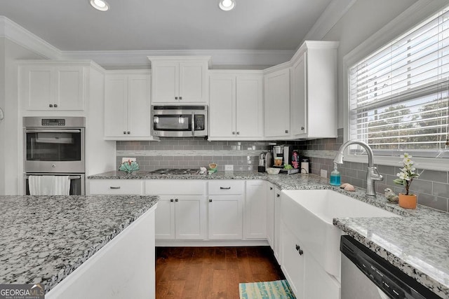 4050 Pleasant Woods Dr, Cumming, GA 30028 - kitchen featuring appliances with stainless steel finishes, crown molding, white cabinetry, dark wood-style floors, and backsplash