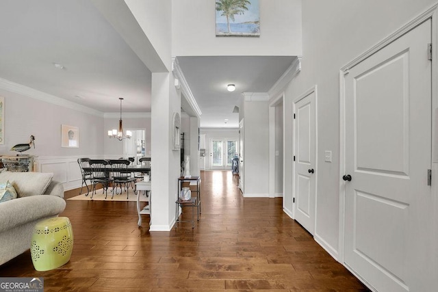 4050 Pleasant Woods Dr, Cumming, GA 30028 - corridor with ornamental molding, a chandelier, dark wood-type flooring, and a wainscoted wall