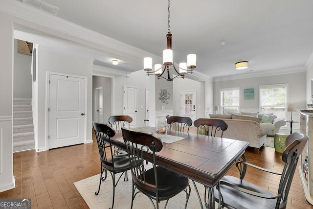 4050 Pleasant Woods Dr, Cumming, GA 30028 - dining space featuring hardwood / wood-style flooring, ornamental molding, stairway, a chandelier, and baseboards