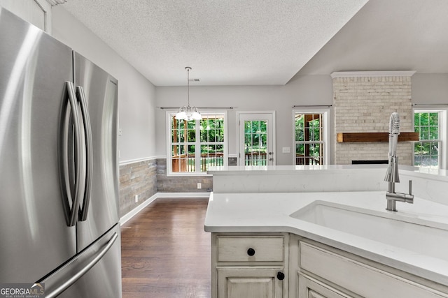 84 Creekside Ct, Zebulon, GA 30295 - kitchen with freestanding refrigerator, a sink, a textured ceiling, plenty of natural light, and a fireplace