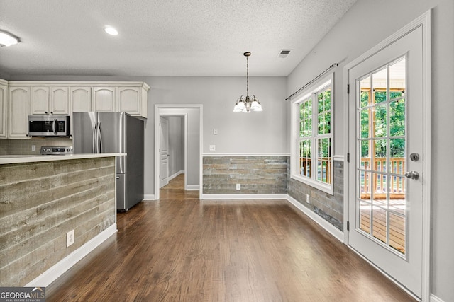 84 Creekside Ct, Zebulon, GA 30295 - kitchen featuring stainless steel appliances, dark wood-style floors, a textured ceiling, baseboards, and a chandelier
