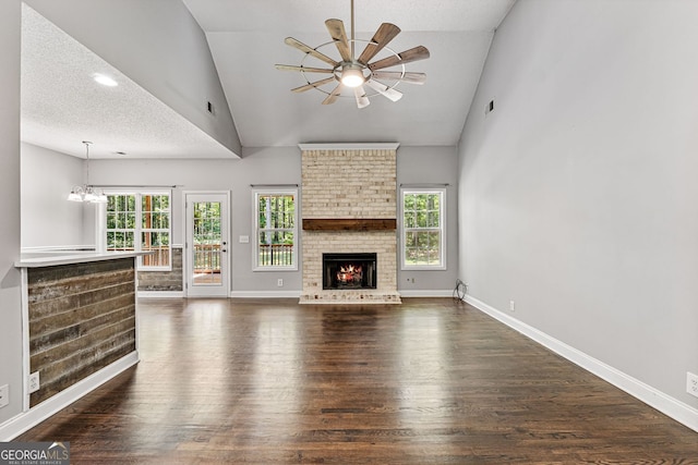 84 Creekside Ct, Zebulon, GA 30295 - unfurnished living room with dark wood-type flooring, a ceiling fan, plenty of natural light, a fireplace, and high vaulted ceiling