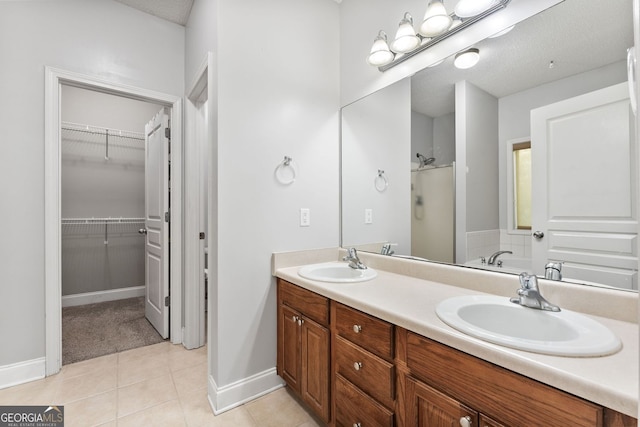 84 Creekside Ct, Zebulon, GA 30295 - bathroom featuring a stall shower, baseboards, double vanity, a walk in closet, and tile patterned floors