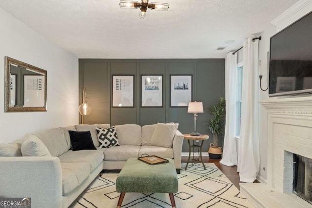 living area with wood finished floors, a fireplace, and a textured ceiling