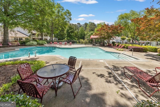 community pool featuring fence and a patio area