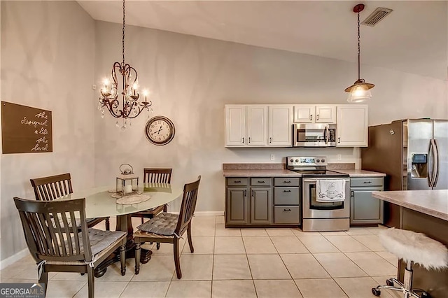 kitchen featuring appliances with stainless steel finishes, high vaulted ceiling, gray cabinets, white cabinetry, and a chandelier