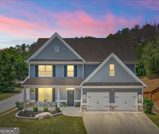 380 Longwood Pl, Dallas, GA 30132 - view of front facade with covered porch, concrete driveway, stone siding, and a lawn