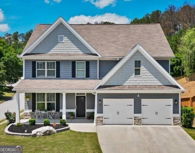 380 Longwood Pl, Dallas, GA 30132 - craftsman inspired home with a porch, concrete driveway, stone siding, and a front lawn