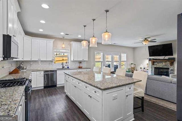 380 Longwood Pl, Dallas, GA 30132 - kitchen featuring dishwasher, range with gas stovetop, ceiling fan, a sink, and backsplash