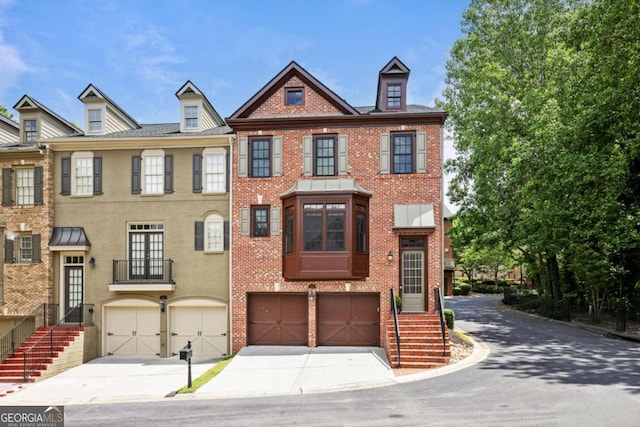view of property with driveway, an attached garage, and brick siding