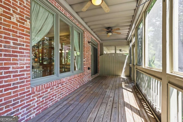 unfurnished sunroom featuring a ceiling fan
