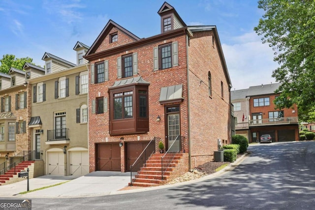 townhome / multi-family property featuring brick siding, an attached garage, and driveway