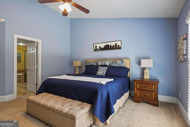carpeted bedroom with baseboards, connected bathroom, and a ceiling fan