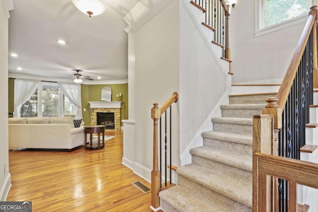 stairs with a ceiling fan, wood finished floors, baseboards, recessed lighting, and crown molding