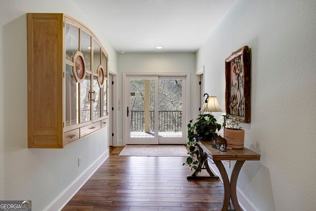 doorway to outside featuring baseboards, dark wood-type flooring, and recessed lighting