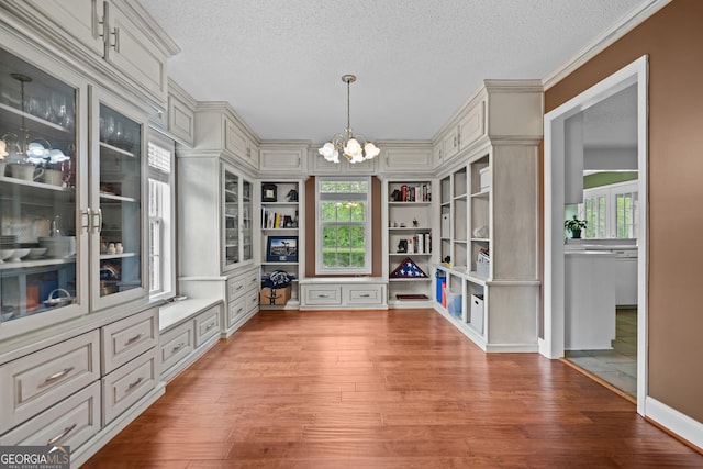 233 Clark Rd, Midville, GA 30441 - unfurnished dining area with a chandelier, wood finished floors, a textured ceiling, built in features, and crown molding
