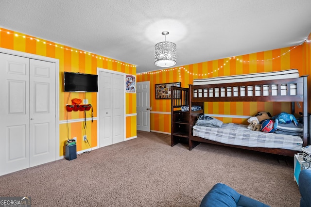 233 Clark Rd, Midville, GA 30441 - bedroom with wallpapered walls, carpet, multiple closets, a textured ceiling, and a chandelier
