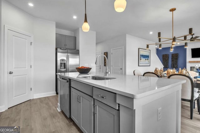 508 Regency Trl, Acworth, GA 30102 - kitchen with a sink, gray cabinets, stainless steel appliances, a chandelier, and light wood-type flooring