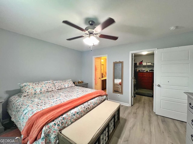 bedroom featuring light wood finished floors, a spacious closet, baseboards, a closet, and a ceiling fan