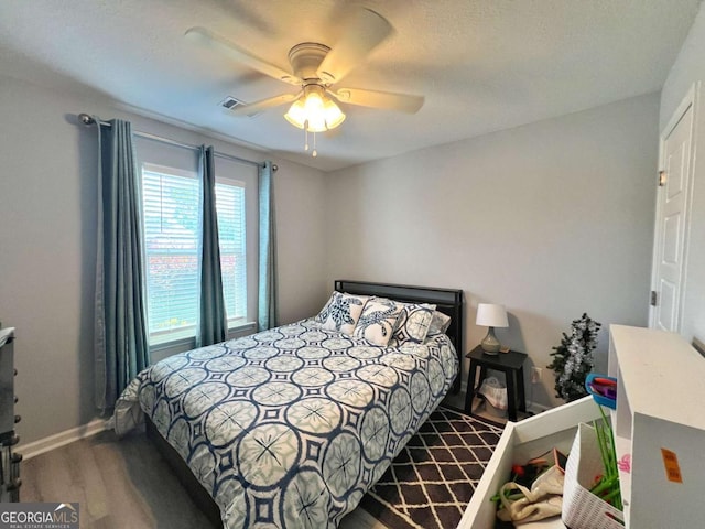 bedroom featuring wood finished floors, baseboards, and a ceiling fan