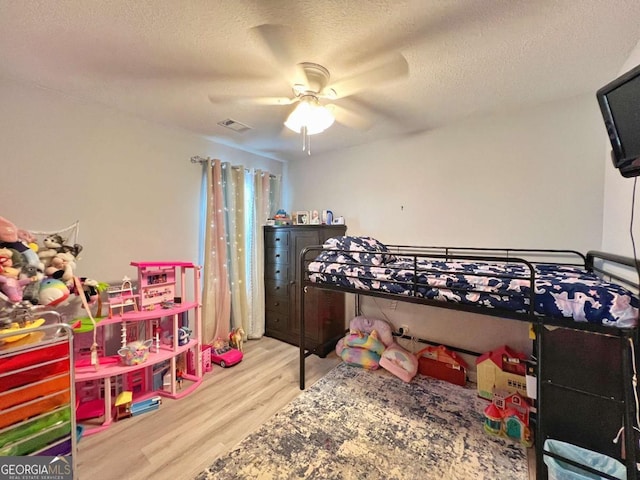 bedroom with wood finished floors, a textured ceiling, and ceiling fan