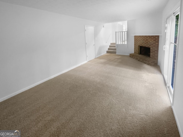 4504 Cedar Ridge Trl, Stone Mountain, GA 30083 - unfurnished living room featuring light carpet, stairs, a brick fireplace, and baseboards