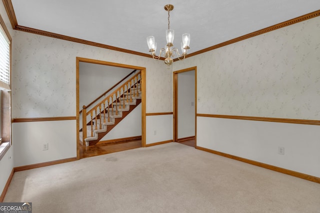 carpeted empty room featuring a chandelier, baseboards, stairway, ornamental molding, and wallpapered walls