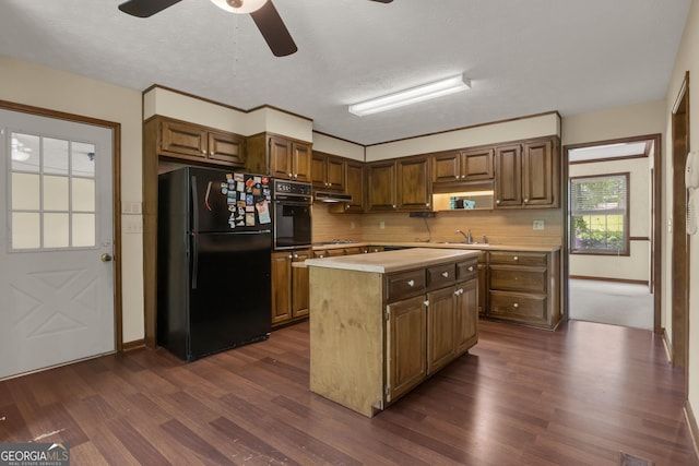 kitchen featuring black appliances, light countertops, ceiling fan, a sink, and backsplash