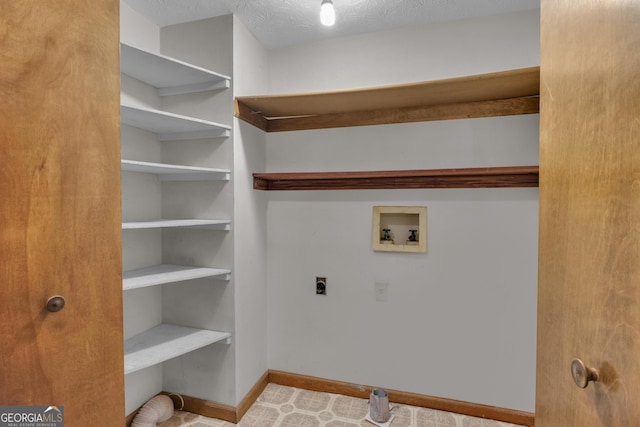 washroom with hookup for an electric dryer, washer hookup, baseboards, and a textured ceiling