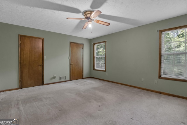 unfurnished room featuring ceiling fan, carpet flooring, baseboards, and a textured ceiling
