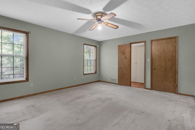 unfurnished bedroom with carpet flooring, baseboards, a textured ceiling, and ceiling fan