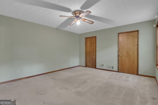 unfurnished bedroom featuring carpet floors, a textured ceiling, baseboards, and a ceiling fan
