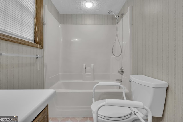 bathroom featuring toilet, a textured ceiling, shower / bath combination, wallpapered walls, and vanity