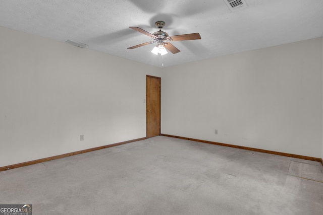 empty room featuring baseboards, a ceiling fan, and light colored carpet
