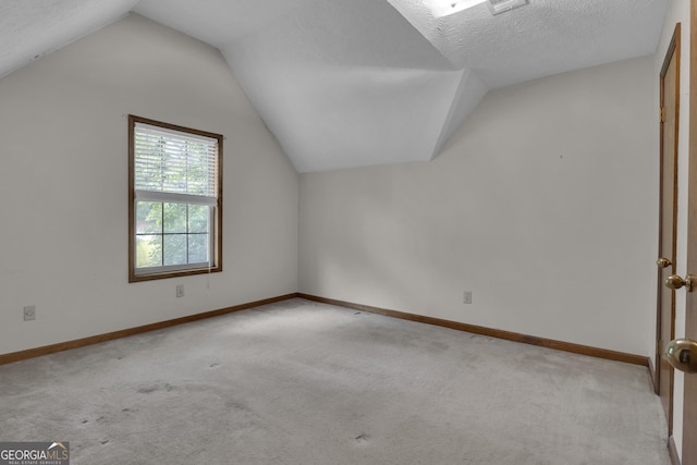additional living space featuring light carpet, lofted ceiling, and baseboards
