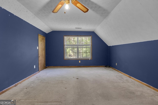 bonus room featuring vaulted ceiling, carpet, baseboards, ceiling fan, and a textured ceiling