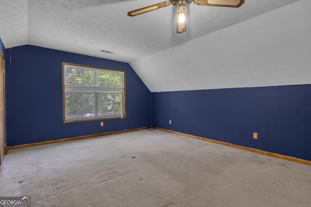 additional living space with lofted ceiling, carpet, ceiling fan, baseboards, and a textured ceiling