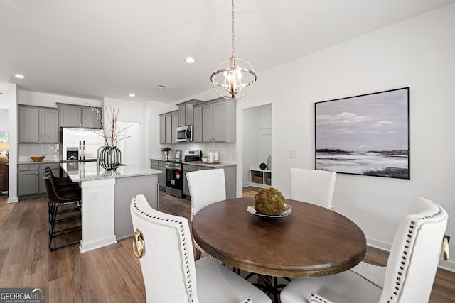 dining room with a chandelier, dark wood-style floors, and recessed lighting