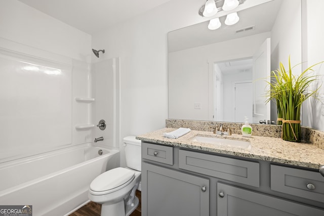 bathroom featuring toilet, vanity, washtub / shower combination, and wood finished floors