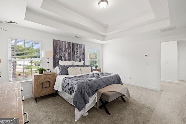 bedroom featuring a tray ceiling, ornamental molding, light colored carpet, and baseboards